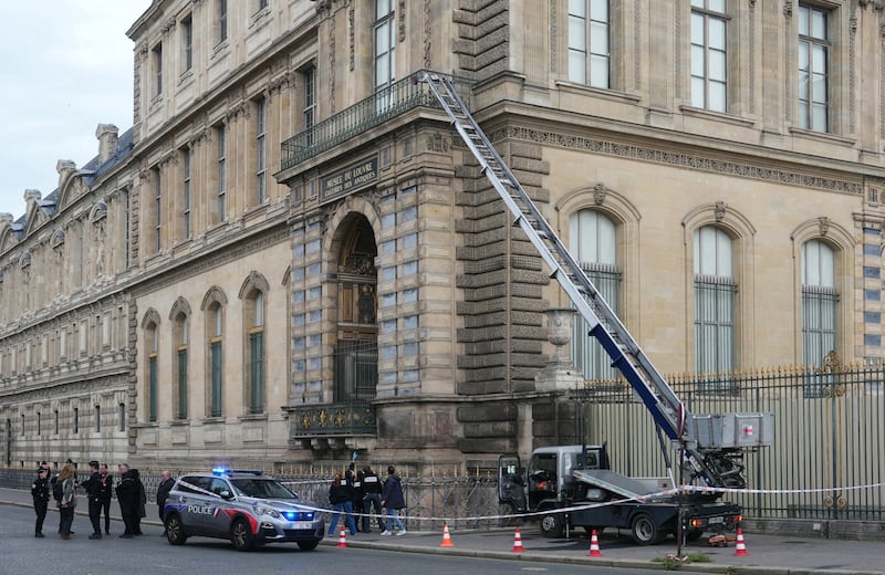 French police officers stand next to a furniture elevator used by thieves to enter the Louvre Museum on Sunday morning. They were in and out of the historic building in under seven minutes.