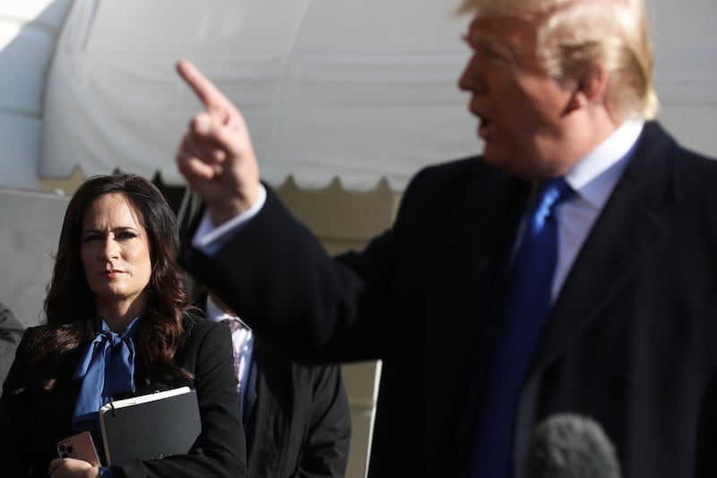 White House Press Secretary Stephanie Grisham (L) listens to U.S. President Donald Trump talk to reporters before he boards Marine One and departing the White House November 08, 2019 in Washington, DC.