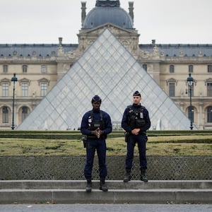 Police stand guard outside the Louvre museum at Louvre on October 19, 2025 in Paris, France.