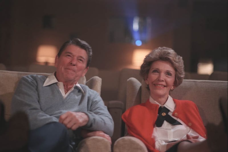 President Ronald Reagan and his wife, Nancy Reagan, watch a film in the White House Family Theater in 1986.