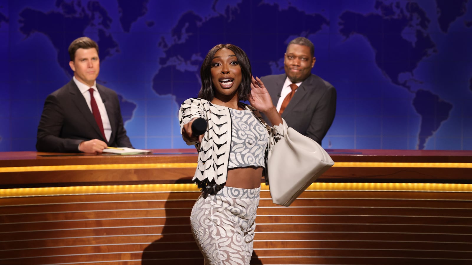 SATURDAY NIGHT LIVE -- Episode 1884 -- Pictured: (l-r) Anchor Colin Jost, Ego Nwodim as Miss Eggy, and anchor Michael Che during Weekend Update on Saturday, May 17, 2025 -- (Photo by: Will Heath/NBC via Getty Images)