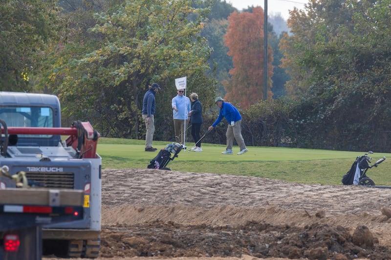 WASHINGTON, DC - OCTOBER 24: Golfers play hole six as trucks unloads debris and soil  from the demolition of the White House's East Wing at East Potomac Golf Course on October 24, 2025 in Washington, DC. The demolition is part of U.S. President Donald Trump's plan to build a multimillion-dollar ballroom on the eastern side of the White House. (Photo by Tasos Katopodis/Getty Images)