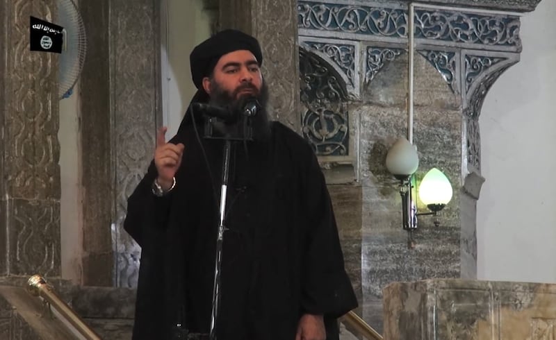 This July 5, 2014 photo shows an image grab taken from a propaganda video released by al-Furqan Media allegedly showing the leader of the Islamic State (IS) jihadist group, Abu Bakr al-Baghdadi, aka Caliph Ibrahim, adressing Muslim worshippers at a mosque in the militant-held northern Iraqi city of Mosul. Baghdadi, who on June 29 proclaimed a "caliphate" straddling Syria and Iraq, purportedly ordered all Muslims to obey him in the video released on social media. In early 2014 the self-styled Islamic State entered the northern Syrian city of Raqqa, declaring it their capital and beginning a reign of terror marked by grisly public executions. Armed sharia police patrolled the streets as "enemies" of the regime were crucified or decapitated, their severed heads impaled on spikes in the city square. (Photo by AFP) (Photo by -/AFP via Getty Images)