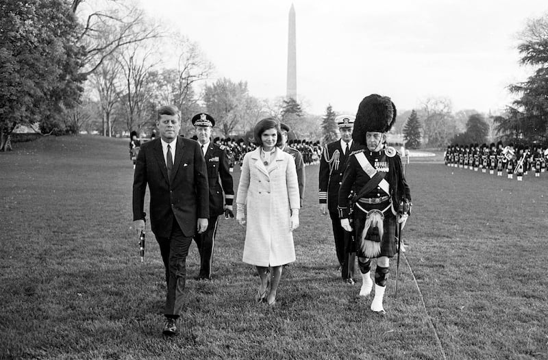 President John F Kennedy, First Lady Jacqueline Kennedy, and Major WM Wingate Gray, right, Commander of the Black Watch walk across the South Lawn of her White House with the Black Watch Royal Highland Regiment in the background on November 13, 1963.