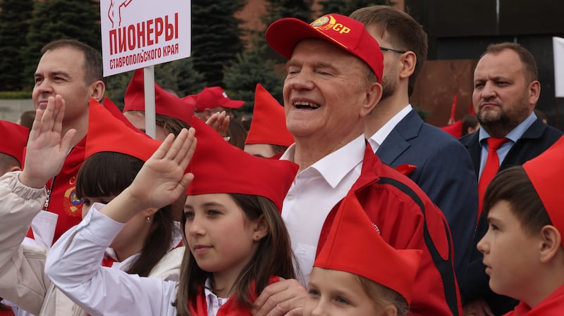 Russian Communist Party's Chairman Gennady Zyuganov (center) poses for a photo with participants during a ceremony for newcomers of the Young Pioneer Organization at Red Square
