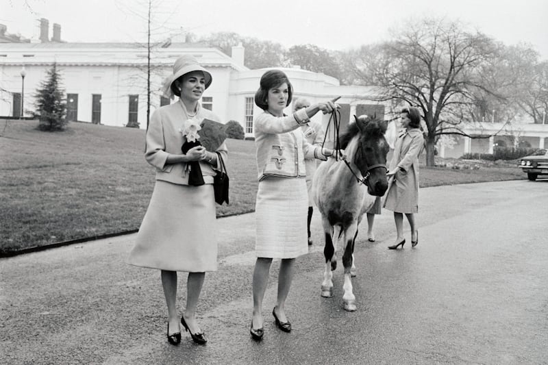 First Lady Jackie Kennedy takes Empress Farah on a tour of the White House grounds on April 12, 1962